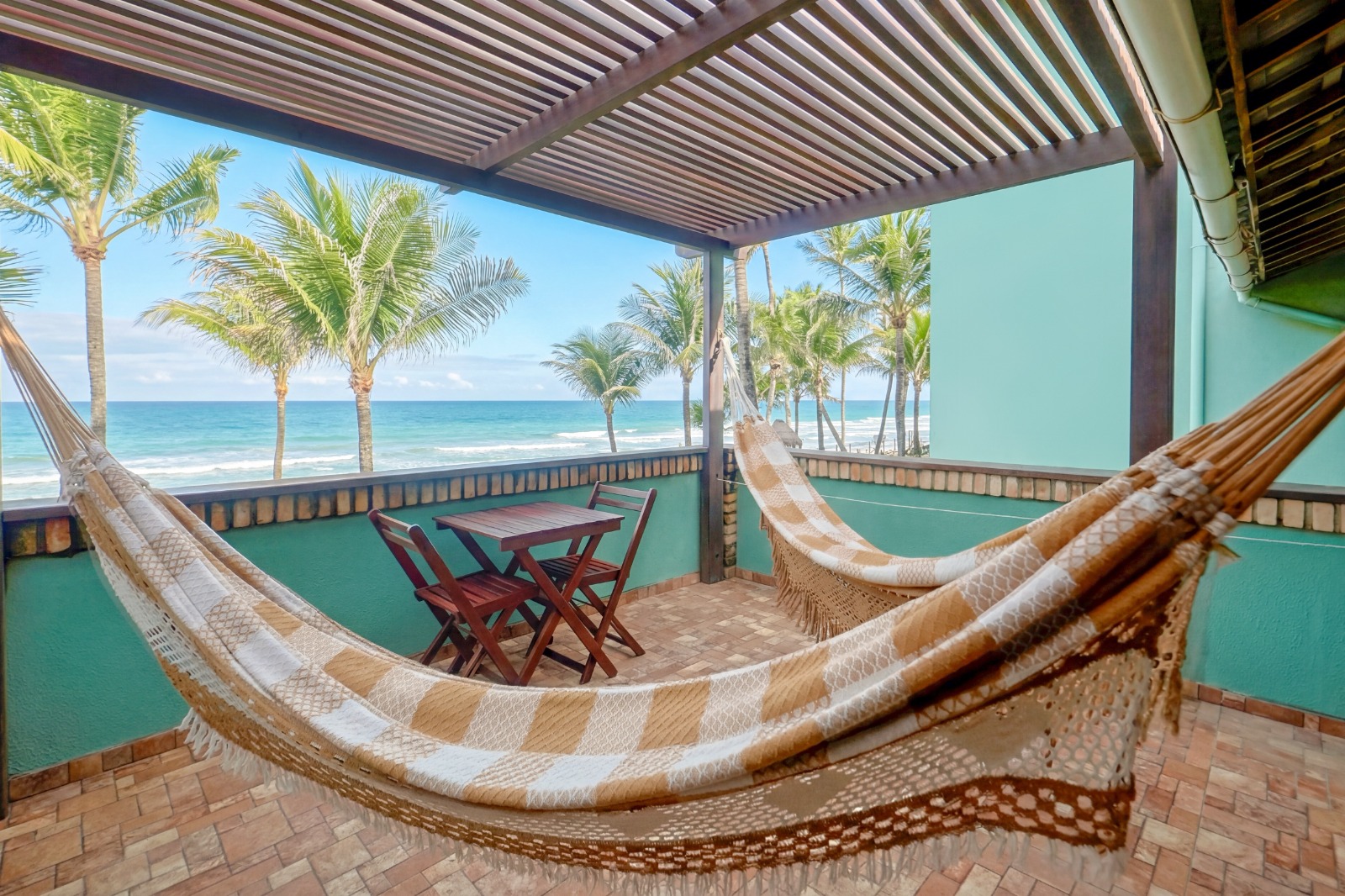 Varanda do Quarto Principal Vista Mar com redes e vista para os coqueiros e o mar