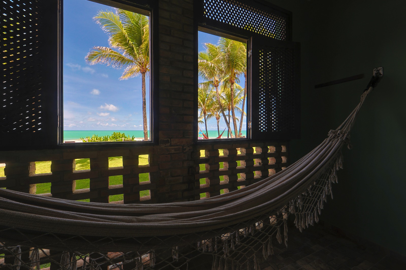 Varanda do Quarto Vista Mar com rede e vista para coqueiros e o mar