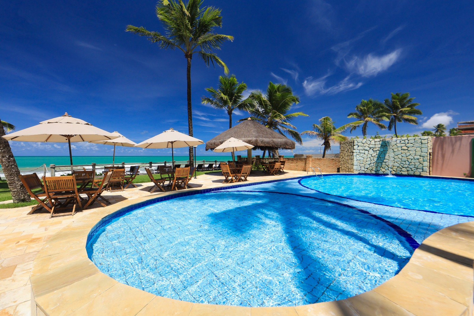 Piscina com ombrelones e vista para o mar